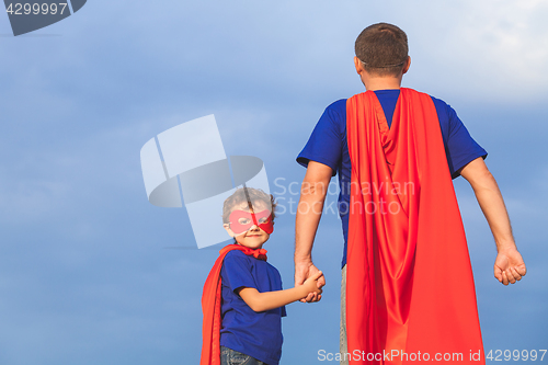 Image of Father and son playing superhero at the day time. 