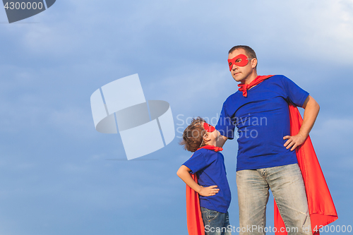Image of Father and son playing superhero at the day time.