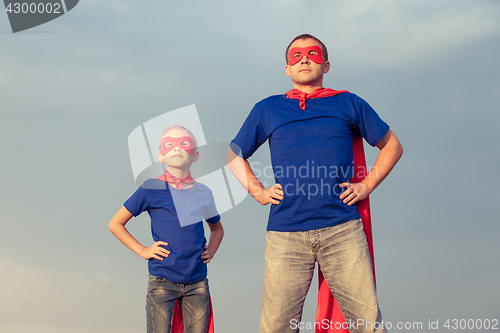 Image of Father and daughter playing superhero at the day time.