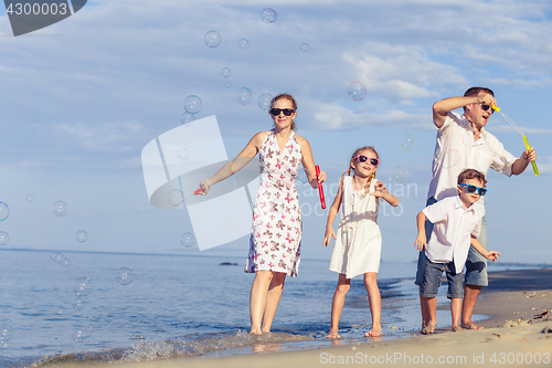 Image of Happy family walking on the beach at the day time.