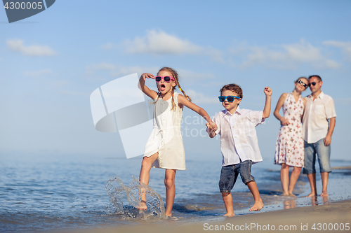 Image of Happy family walking on the beach at the day time.