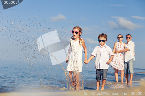 Image of Happy family walking on the beach at the day time.