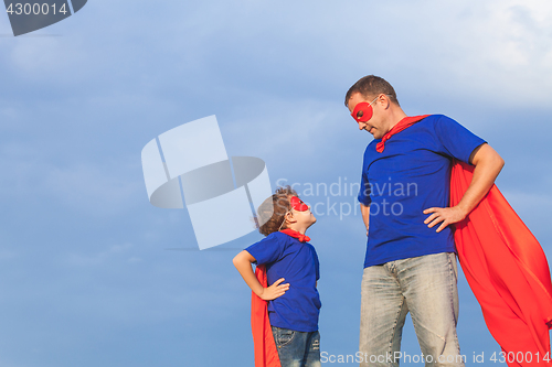 Image of Father and son playing superhero at the day time.