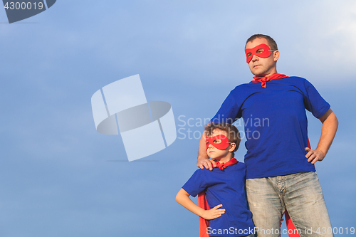 Image of Father and son playing superhero at the day time.