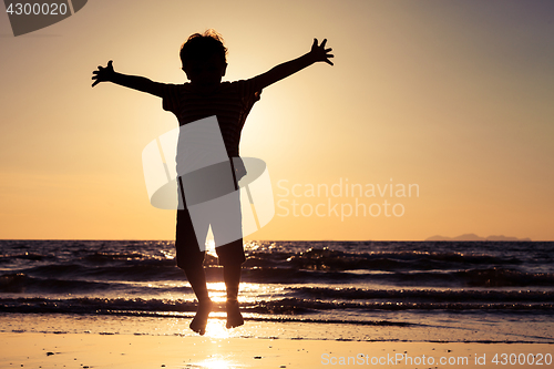 Image of Happy little boy jumping on the beach 