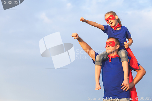 Image of Father and daughter playing superhero at the day time.