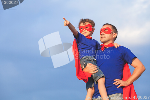 Image of Father and son playing superhero at the day time.