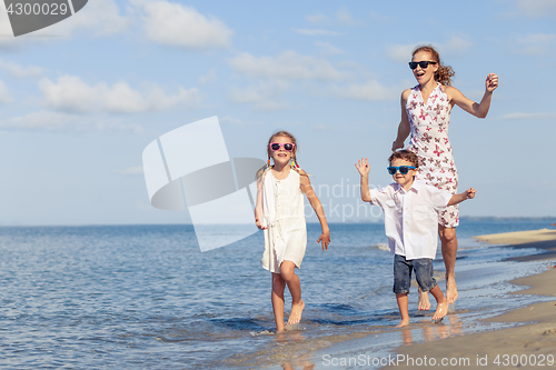 Image of Mother and children playing on the beach at the day time.