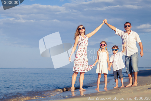 Image of Happy family walking on the beach at the day time.