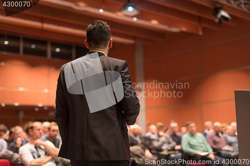 Image of Public speaker giving talk at Business Event.