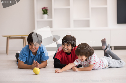 Image of boys having fun with an apple on the floor