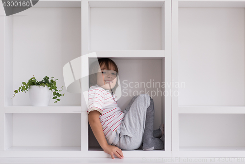 Image of young boy posing on a shelf