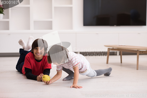 Image of boys having fun with an apple on the floor