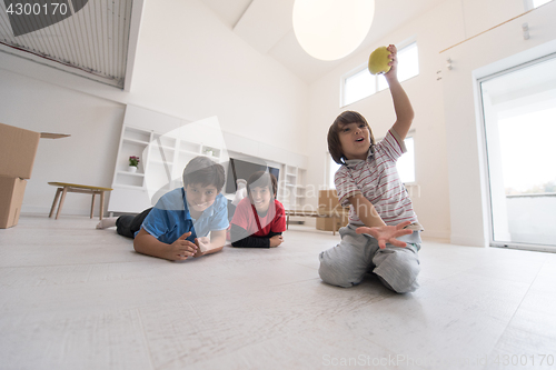 Image of boys having fun with an apple on the floor