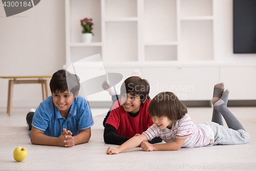 Image of boys having fun with an apple on the floor