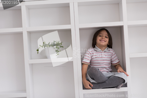 Image of young boy posing on a shelf