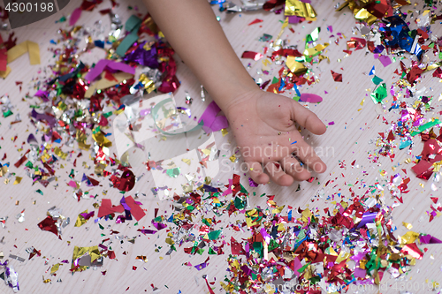 Image of Children\'s hand with confetti in background