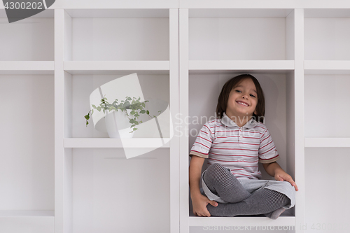 Image of young boy posing on a shelf