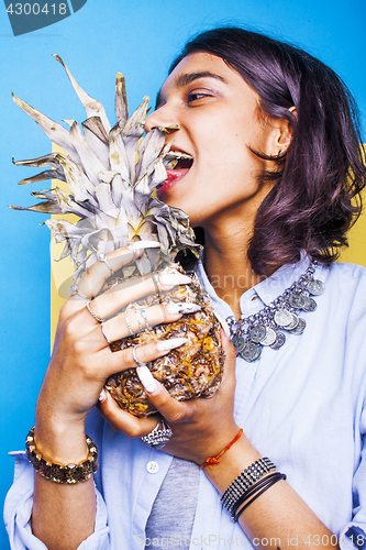 Image of lifestyle people concept. young pretty smiling indian girl with pineapple, asian summer fruits 