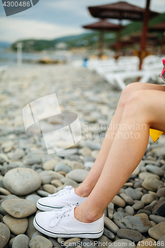 Image of Crop female legs on pebble beach