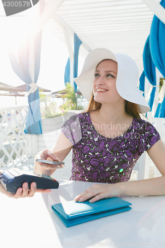 Image of Smiling woman paying with smartphone