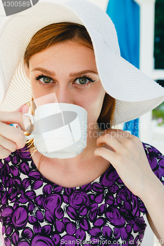 Image of Model in summer outfit drinking coffee