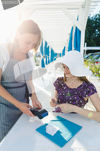 Image of Woman paying for meal in cafe