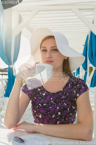 Image of Model in summer outfit drinking coffee