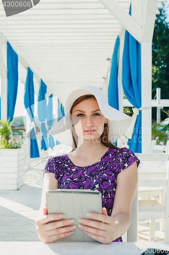 Image of Stylish girl with gadgets in summer cage