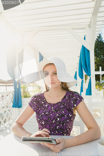 Image of Stylish girl with gadgets in summer cage