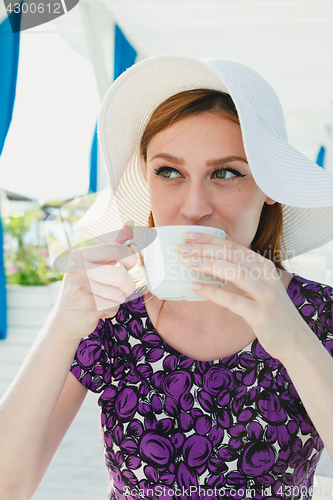 Image of Model in summer outfit drinking coffee