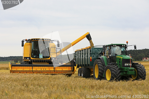 Image of New Holland Combine Unloads Grain onto Trailer