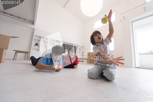 Image of boys having fun with an apple on the floor