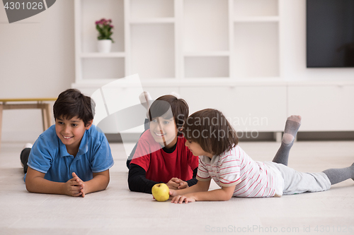 Image of boys having fun with an apple on the floor