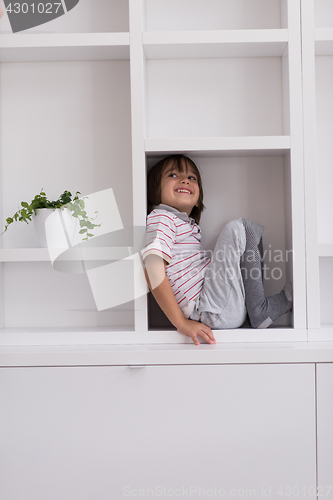 Image of young boy posing on a shelf