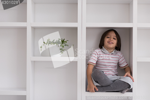 Image of young boy posing on a shelf