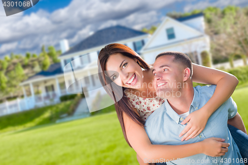 Image of Playful Young Military Couple Outside A Beautiful New Home.