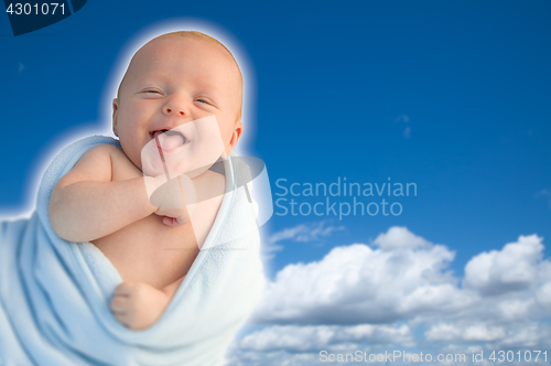 Image of Beautiful Laughing Baby Boy Wrapped in His Blanket With A Blue S