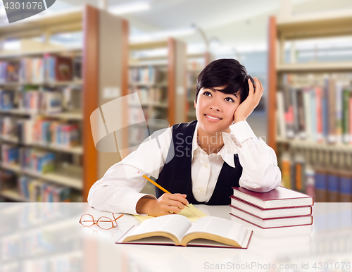 Image of Young Female Mixed Race Student With Books and Paper Daydreaming