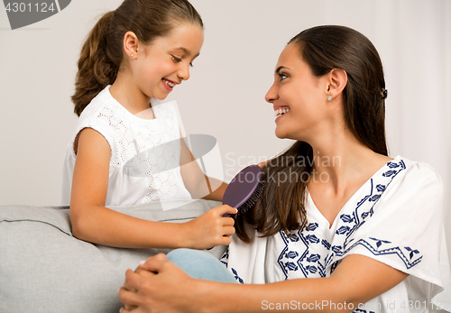 Image of Lelping mother brushing hair