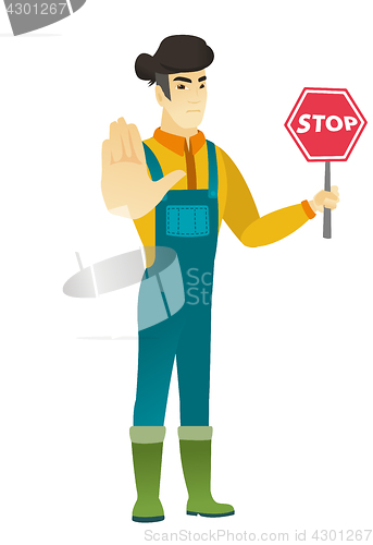 Image of Asian farmer holding stop road sign.