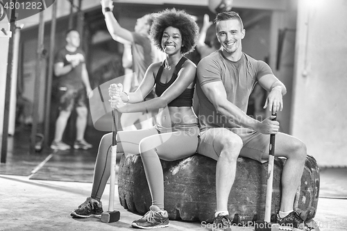 Image of multiethnic couple after workout with hammer