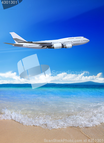 Image of beach and blue sky with plane 