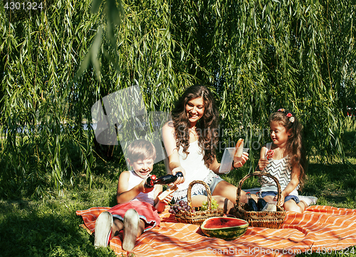 Image of cute happy family on picnic laying on green grass mother and kid