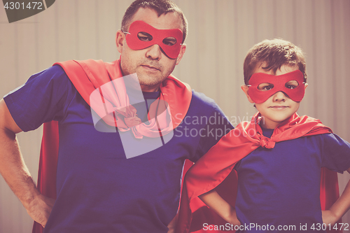 Image of Father and son playing superhero outdoors at the day time.