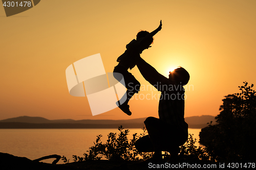 Image of father and son playing on the coast of lake