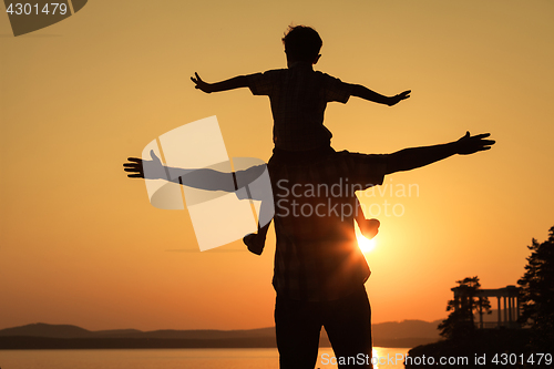 Image of father and son playing on the coast of lake