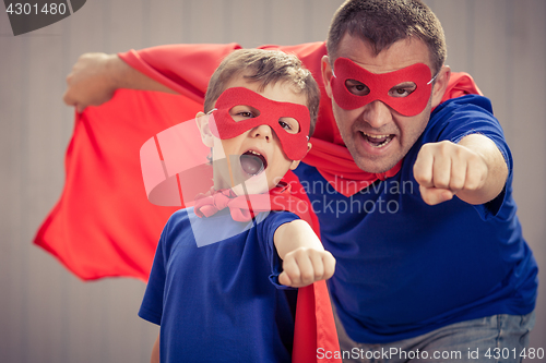 Image of Father and son playing superhero outdoors at the day time.