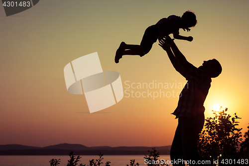 Image of father and son playing on the coast of lake