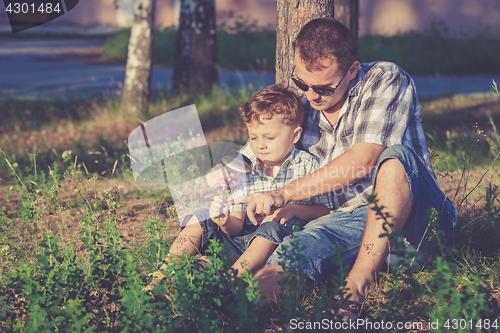 Image of Father and son playing in the park at the day time.